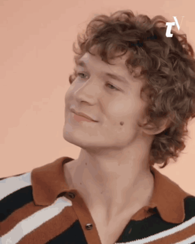 Curly Haired Young Man Smiling in Striped Shirt