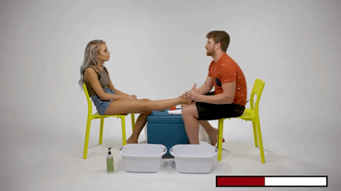 Cute Sitting Couple Doing Foot Massage GIF