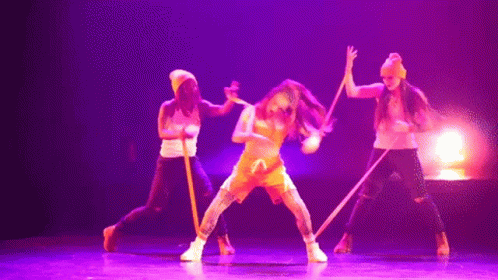 Dancers Performing on Stage With Purple Lighting