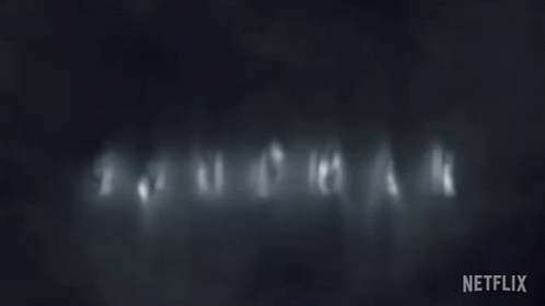 Dark Background With Sandman In White Letters GIF