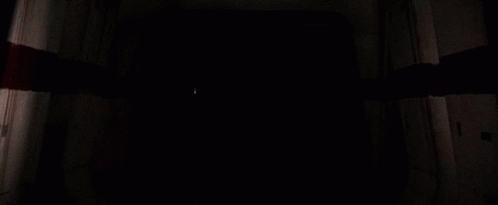 Darth Vader Holding A Red Light Saber In A Dark Room GIF