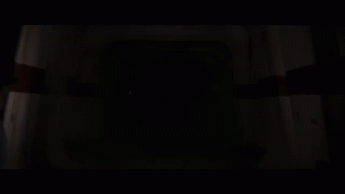 Darth Vader Holding A Red Lightsaber In A Dark Room GIF
