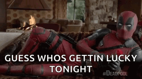Deadpool Is Laying On A Couch In A Living Room Holding A Rose . GIF