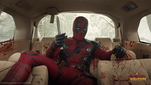 Deadpool Is Sitting In The Back Seat Of A Car With A Knife In His Hand GIF