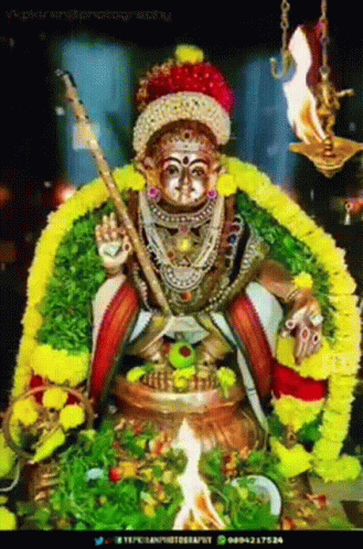 Deity Statue With Sword and Flowers
