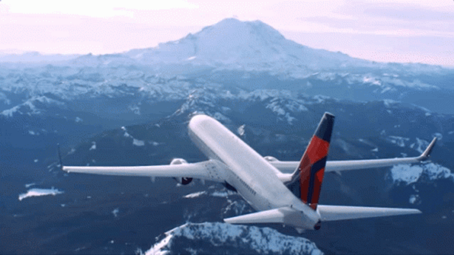 Delta Airline Flying Above Snowy Mountains GIF