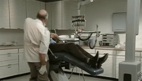 Dentist Examining Patient's Teeth In Dental Chair GIF