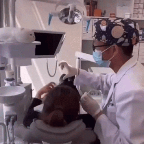 Dentist In Mask And Gloves Examining Patient's Teeth GIF