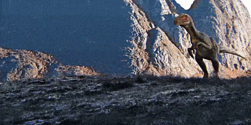Dinosaur Standing In Front Of Rocky Cliff GIF