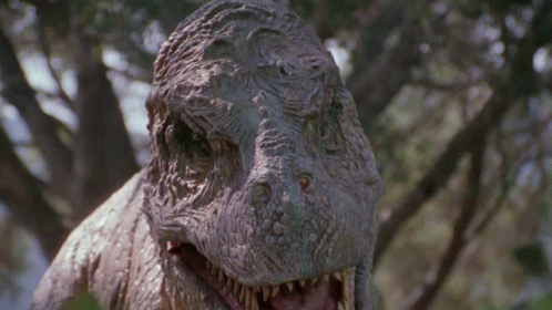 Dinosaur Statue With Open Mouth Looking At Camera GIF