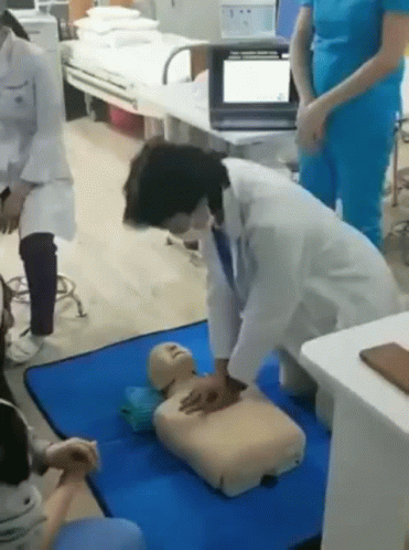 Doctor Practicing on Dummy in Hospital