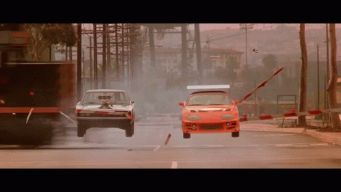 Dodge Charger and Red Sports Car Racing Down City Street
