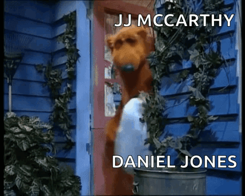 Dog Standing in Front of Door with JJ McCarthy and Daniel Jones