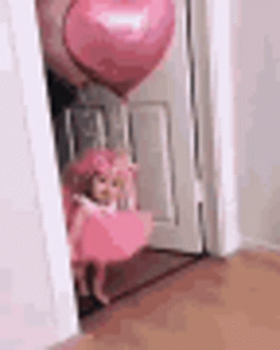 Doll in Pink Dress Next to Pink Heart Balloon in Doorway