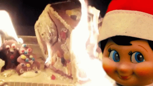 Doll In Santa Hat Watching Burning Cake GIF