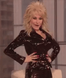 dolly parton is wearing a black sequined jacket and a black dress .