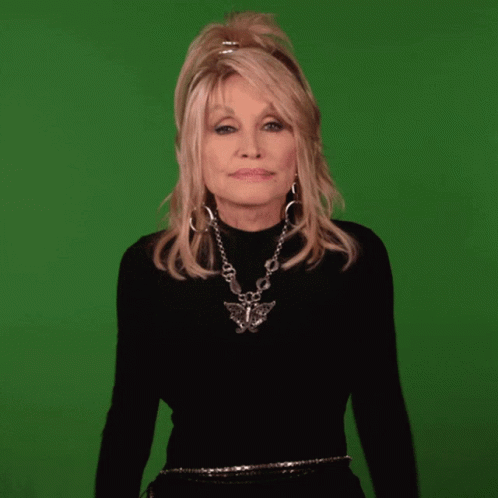 dolly parton is wearing a black turtleneck and a silver necklace