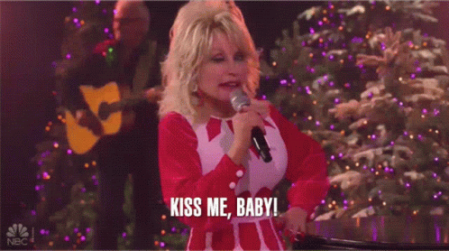 Dolly Parton Singing Into Microphone Saying Kiss Me Baby