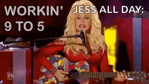 Dolly Parton Singing Into Microphone With Guitar and Red Dress