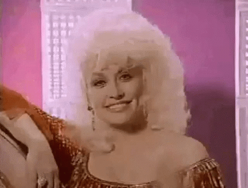 Dolly Parton Smiling in Gold Dress and Earrings