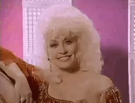 Dolly Parton Smiling in Gold Dress and Earrings