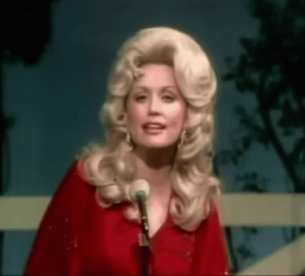 Dolly Parton Standing in Front of a Microphone