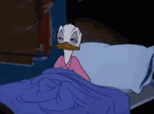 Donald Duck Is Laying In A Bed With A Blue Blanket GIF