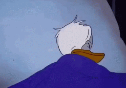 Donald Duck Is Laying In A Bed With A Blue Blanket On Top Of Him . GIF