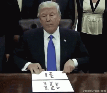 Donald Trump at Table with Donald Draws.com Sign