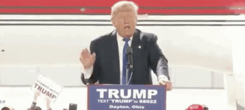 Donald Trump Is Giving A Speech At A Podium While Wearing A Fake Face . GIF