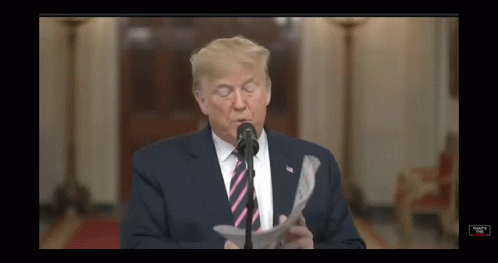 Donald Trump Is Speaking Into A Microphone While Reading A Piece Of Paper GIF