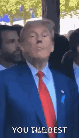 donald trump is wearing a blue suit and red tie and says you the best .