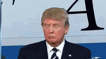 Donald Trump Is Wearing A Suit And Tie While Standing In Front Of A Sign That Says A . GIF
