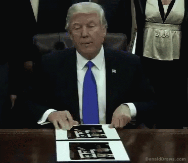 Donald Trump Sitting at Desk With Self Portrait
