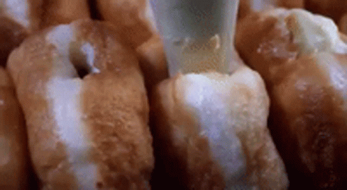 Donuts with Icing Being Poured