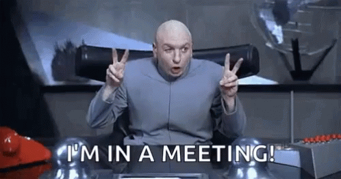 Dr. Evil Giving Peace Sign at Desk Meeting