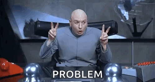Dr. Evil Is Giving A Peace Sign While Sitting At A Desk With The Word Problem Behind Him . GIF
