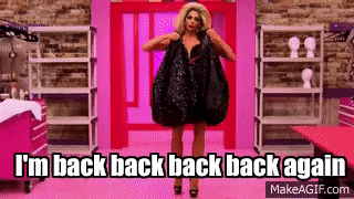 Drag Queen in Black Dress Holding Bag Against Pink Wall