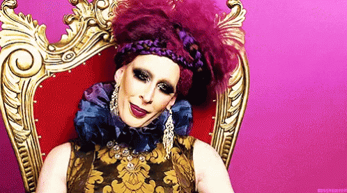 Drag Queen in Purple and Gold Dress With Earrings