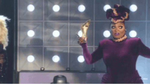 Drag Queen in Purple Dress Holding High Heels