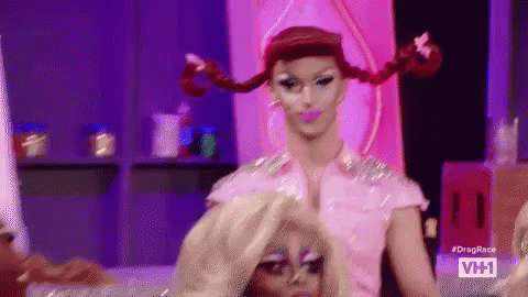 Drag Queen Putting Wig on Another Drag Queen on Stage