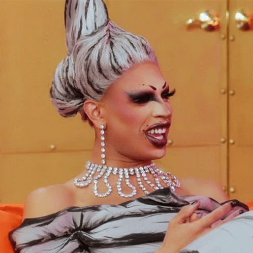 Drag Queen Wearing Pearls And Earrings GIF