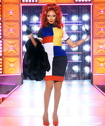 Drag Queen With Red Hair Walking Down Runway Holding Fur Coat