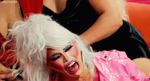 Drag Queen With White Hair and Pink Lipstick Held by Another Drag Queen