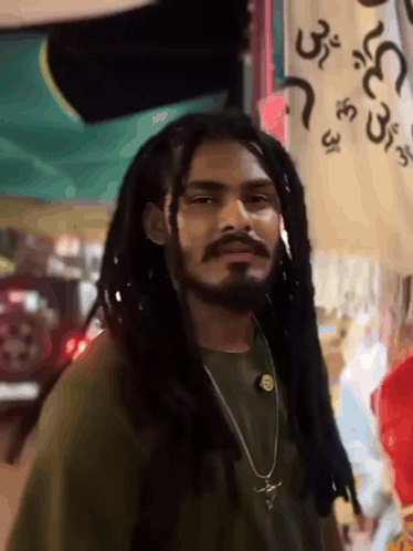 Dreadlocked Bearded Man Near Arabic Sign