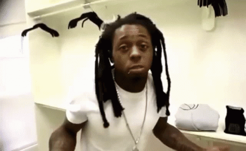 Dreadlocked Man in White Shirt in Closet