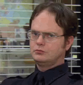 Dwight Schrute Is Wearing Glasses And A Black Shirt And Tie . GIF