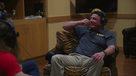 Ed Orgeron Holding Up His Fist While Laughing GIF