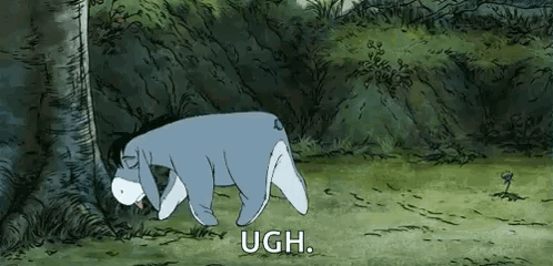 Eeyore From Winnie The Pooh Is Laying Down In The Grass Next To A Tree . GIF