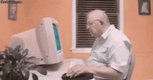 Elderly Man Typing on Keyboard at Computer
